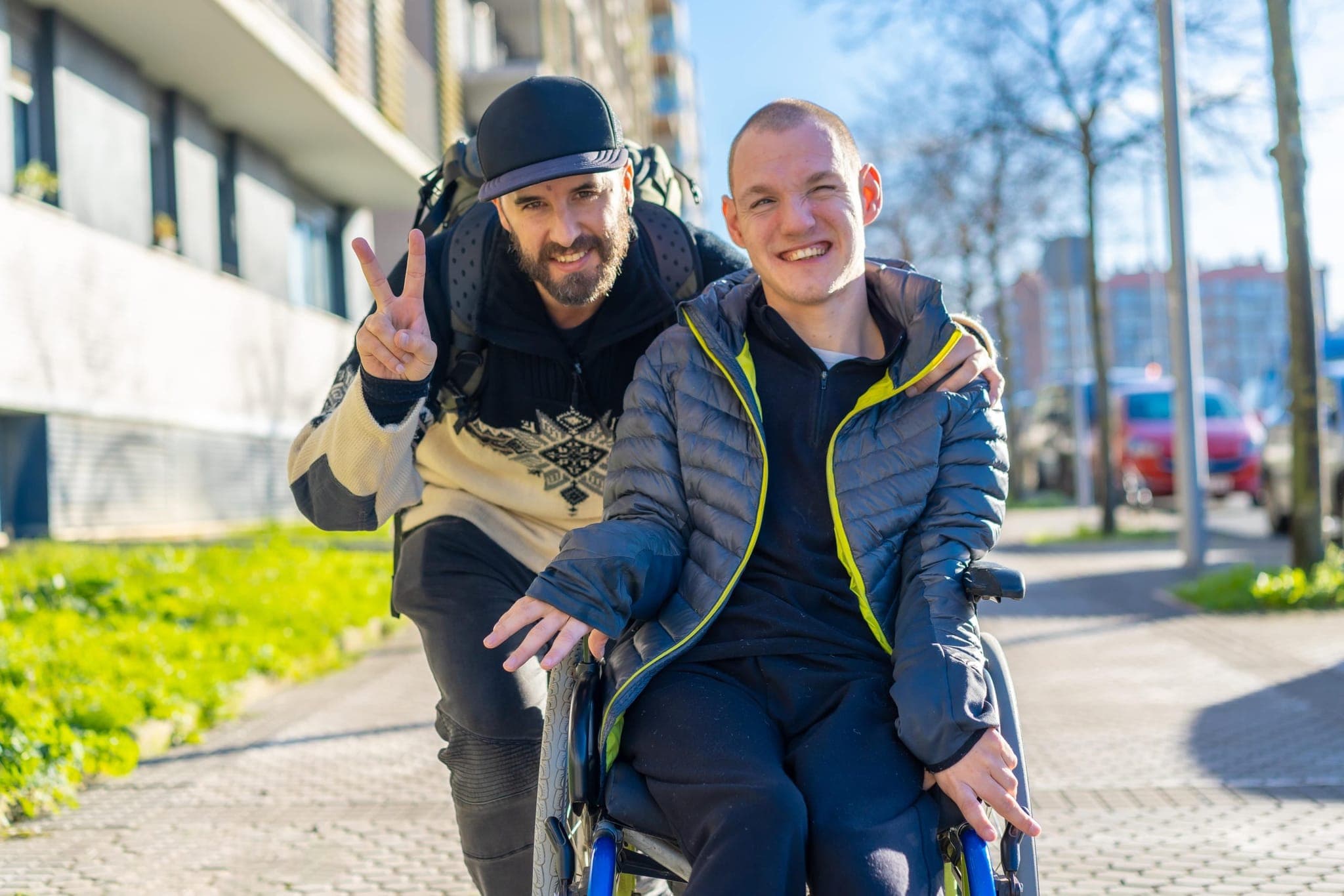 Två vänner ute på promenad, den ena i rullstol
